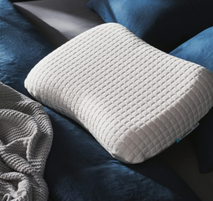 IKEA White textured memory foam pillow on blue bedding.
